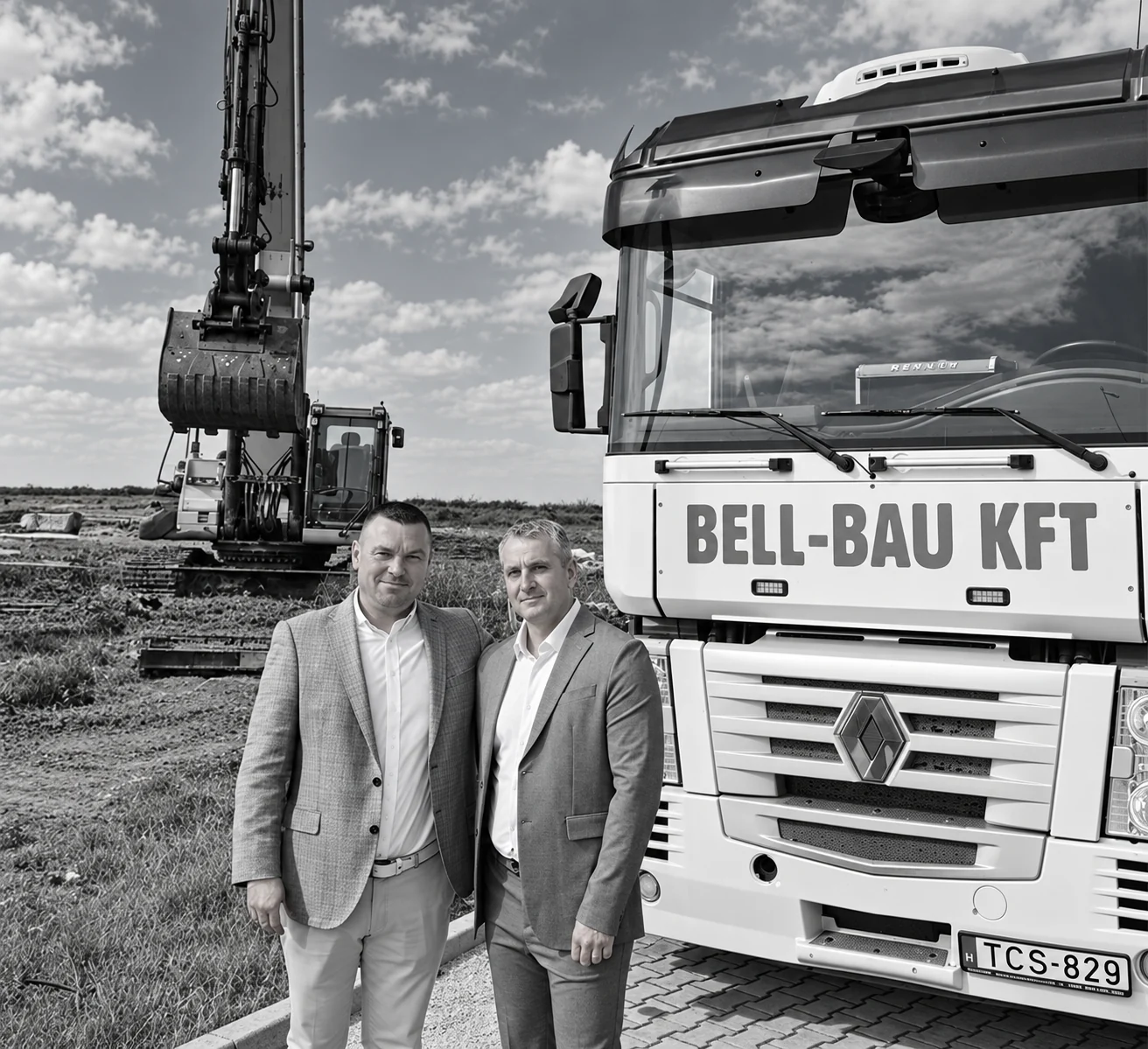 A Bell-Bau vezetői a vállalkozás teherautója és kotrógépe mellett